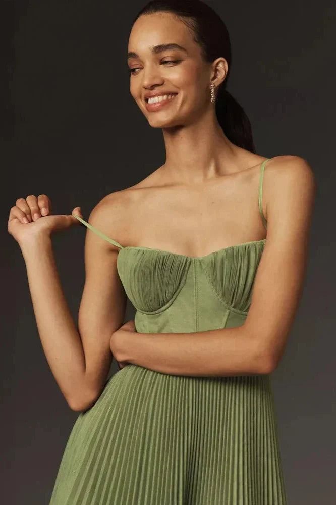 Naheinstellung des Isabella Plissiertes Tüll-Midikleid von Fadenburg, Modell lächelt im romantischen Bustier-Design in sanftem Olivgrün.